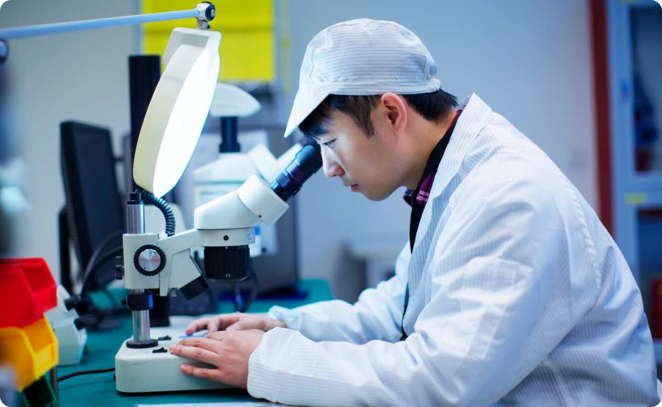 Researcher looking through a microscope.