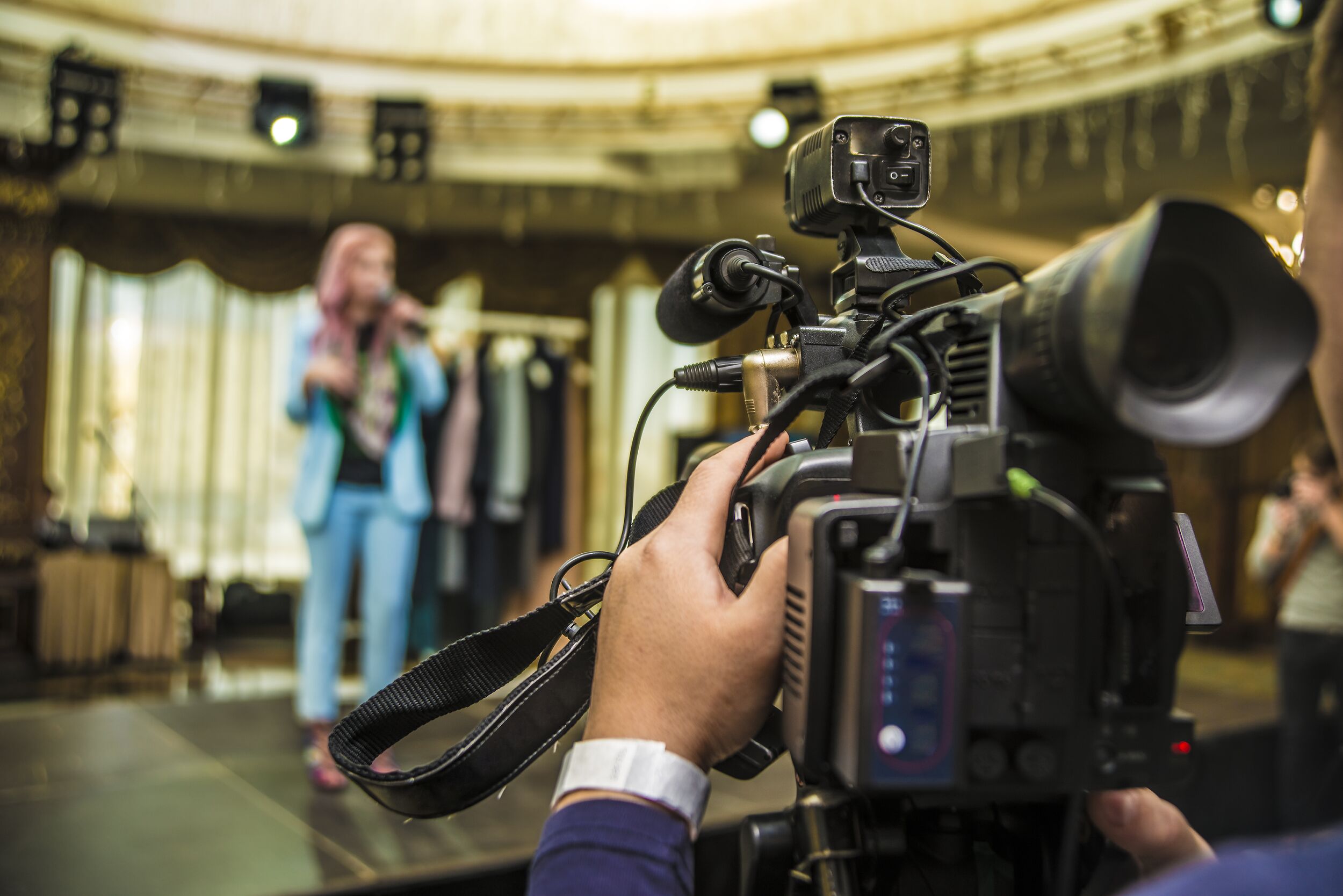 Television camera recording a singing performance.