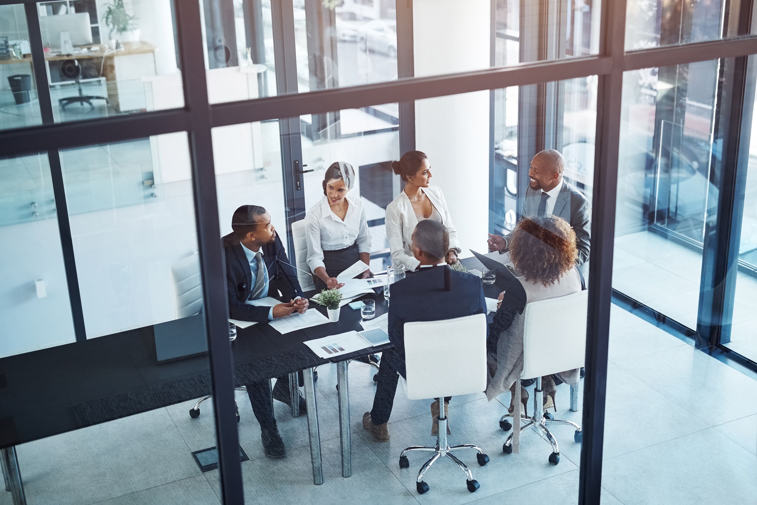 Business meeting in a glass conference room.