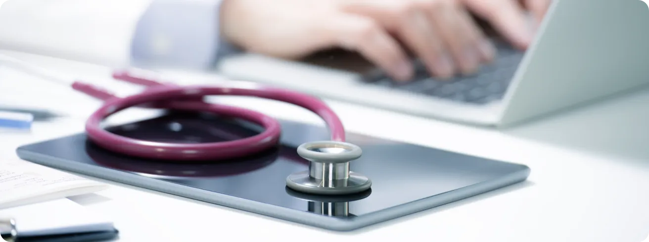 A stethoscope placed on top of a touchscreen tablet.