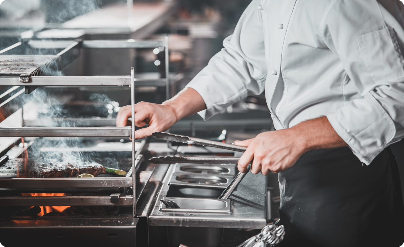 A chef grills food items
