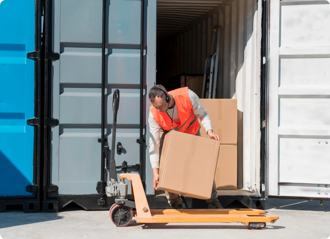 A man loads a box from a truck onto a dolly