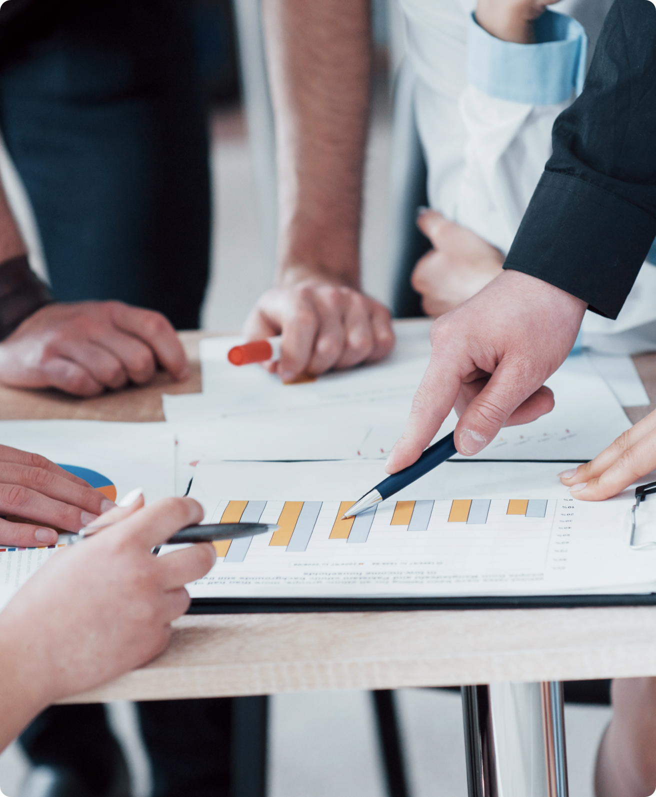 A group of coworkers discussing and point to a bar chart.