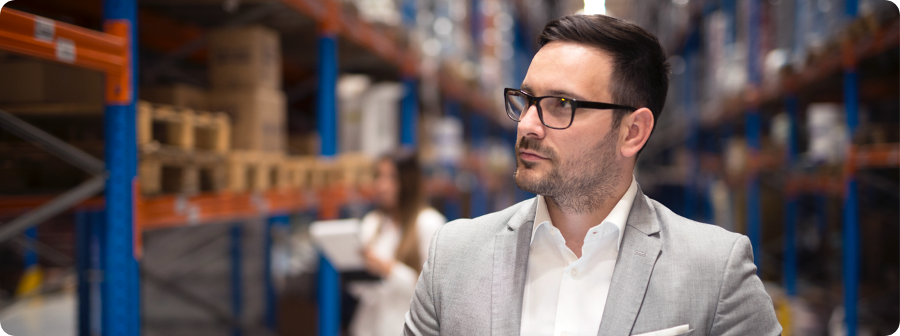 Portrait Successful Businessman Manager CEO Holding Tablet Walking Through Warehouse Storage Area Looking Towards Shelves
