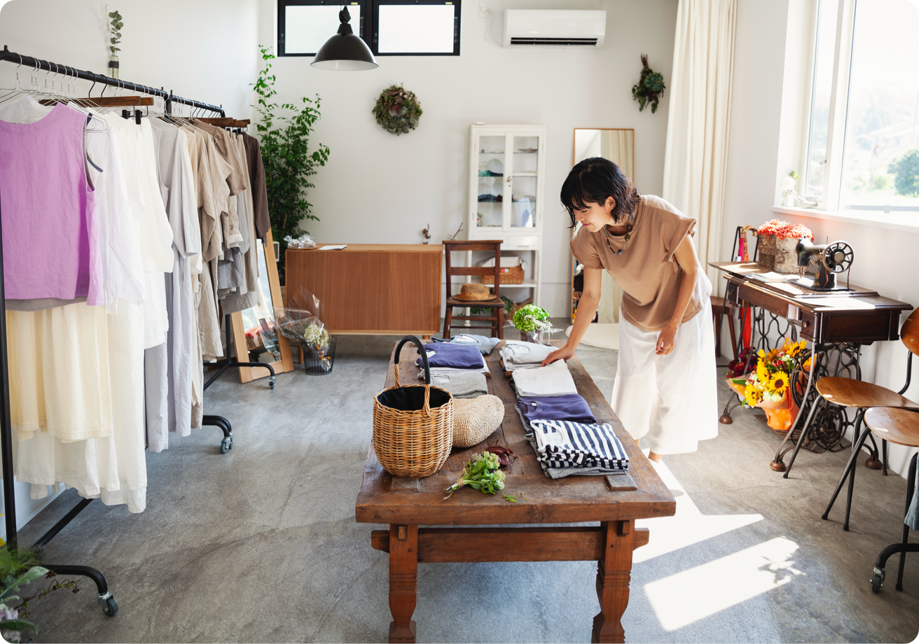 Clothing store shop keeper straightening up.