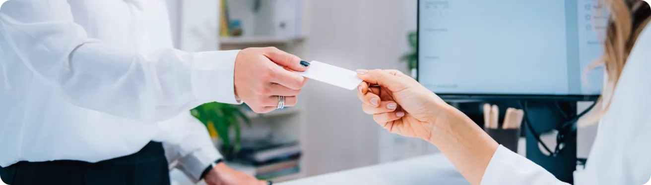 One person offers a card to another